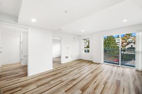 Seattle apartment for rent - A spacious room with wooden flooring and white walls.