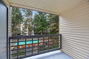 Everett apartment for rent - A balcony with a view of a pool and trees.