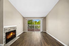 Bellevue townhouse for rent - A room with a fireplace and a view of a balcony with trees.