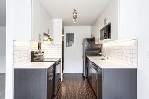 Seattle apartment for rent - a kitchen with stainless steel appliances and white counter tops