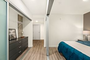 Seattle apartment for rent - A bedroom with a bed, dresser, and mirror.
