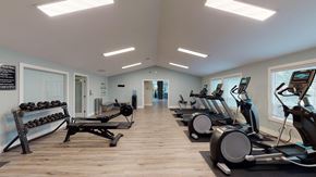 Bothell apartment for rent - a gym with cardio machines and weights on a wooden floor