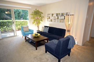 Seattle apartment for rent - a living room with a couch and chairs and a sliding glass door