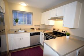 Seattle apartment for rent - a kitchen with white cabinets and stainless steel appliances