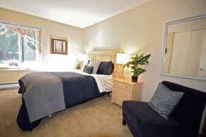 Seattle apartment for rent - a bedroom with a bed and a chair and a window