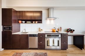 Seattle apartment for rent - a kitchen with dark wood cabinets and white countertops