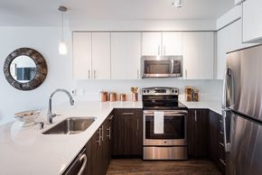 Kirkland apartment for rent - a kitchen with white countertops and dark wood cabinets
