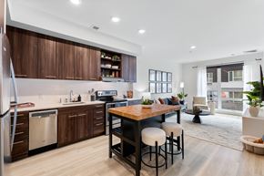 Portland apartment for rent - A modern kitchen with wooden cabinets and a dining table with four chairs.