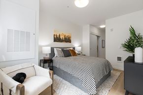 Portland apartment for rent - A bedroom with a bed, a chair, and a painting on the wall.