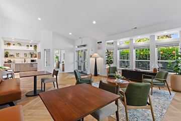 Vancouver townhouse for rent - A modern living room with a wooden table and green chairs.