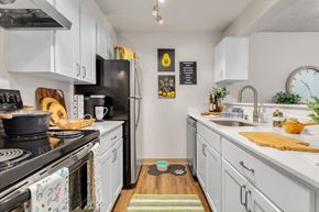 Kent apartment for rent - a kitchen with white cabinets and a black stove and refrigerator