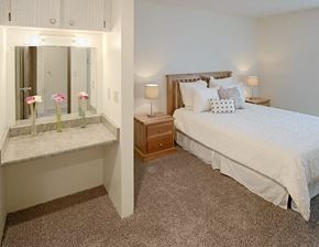 Tacoma apartment for rent - a bedroom with a bed and a counter with flowers