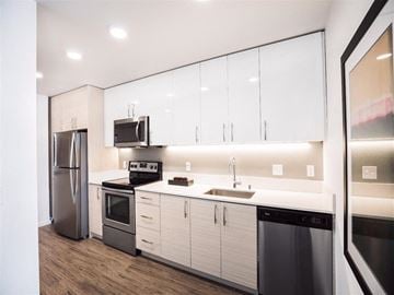 Seattle apartment for rent - A modern kitchen with white cabinets and stainless steel appliances.