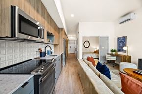 Seattle apartment for rent - A modern kitchen with a long counter and a microwave above it.