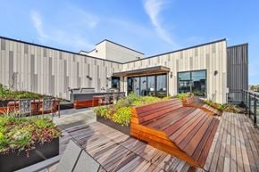 Seattle apartment for rent - A modern building with a wooden deck and planters in front.