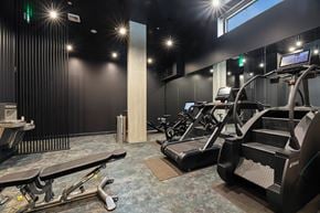 Seattle apartment for rent - A gym with treadmills, a bench, and a table.