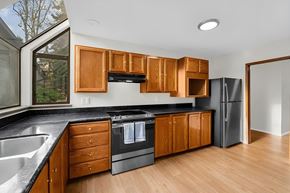 Kent apartment for rent - A kitchen with wooden cabinets and black countertops.