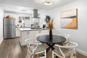 Burien apartment for rent - A modern kitchen with a dining table set for four.