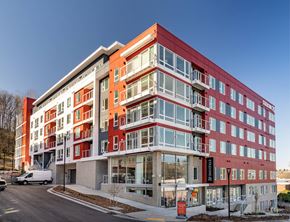Seattle apartment for rent - A modern multi-story building with a red and white facade.