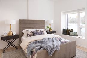Seattle apartment for rent - A bedroom with a bed covered in a grey blanket and a grey headboard.