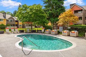 Kent apartment for rent - a swimming pool with chairs and a house in the background