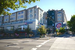 Seattle apartment for rent - A city street with a large building on the corner with a sign that says "Famous".