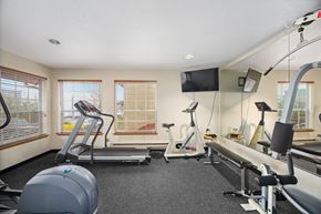 Seattle apartment for rent - A spacious home gym with a variety of equipment including treadmills, elliptical machines, and weight machines.