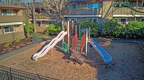 Vancouver apartment for rent - a playground with slides and chairs in front of an apartment building
