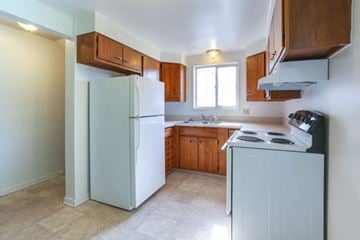 Williamsville house for rent - A kitchen with a white refrigerator and a white stove top oven.