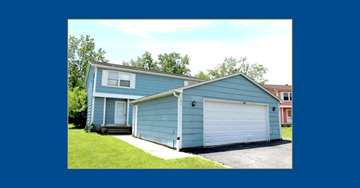 Amherst triplex for rent - A blue house with a white garage door.