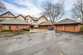 Williamsville condo for rent - A parking lot in front of a building with a blue trash can.