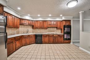 Williamsville condo for rent - A kitchen with wooden cabinets and black appliances.