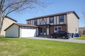 Amherst townhouse for rent - A black car is parked in front of a two-story house.