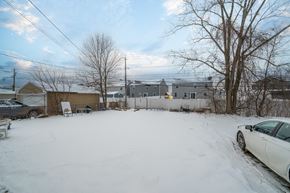 Amherst triplex for rent - A white car is parked in a snowy yard.
