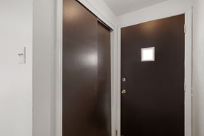 Amherst triplex for rent - A brown door with a light switch on the wall.