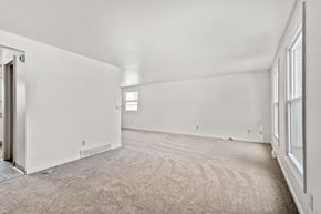 Amherst triplex for rent - A spacious room with a carpeted floor and white walls.