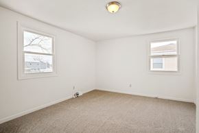 Amherst triplex for rent - A room with a carpet floor and two windows.