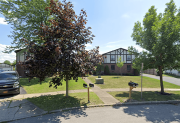 Amherst triplex for rent - A tree with red leaves stands in front of a brick building.