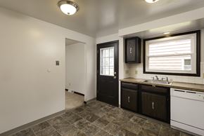Amherst triplex for rent - A bathroom with a black door and a white sink.