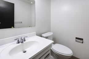 Amherst triplex for rent - A white sink with a mirror above it and a toilet next to it.