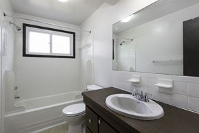 Amherst triplex for rent - A white bathroom with a toilet, sink, and tub.