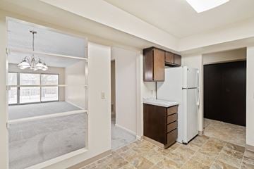 Amherst condo for rent - A kitchen area with a white refrigerator and brown cabinets.