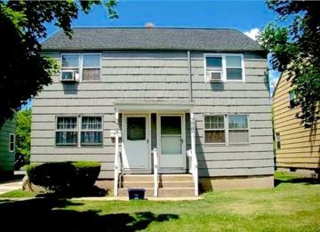 Buffalo triplex for rent - A grey house with a white door and windows.
