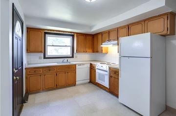 Williamsville triplex for rent - A kitchen with wooden cabinets and a white refrigerator.
