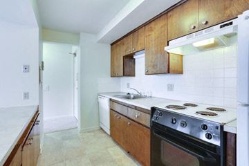 Kenmore apartment for rent - A kitchen with a white oven and wooden cabinets.