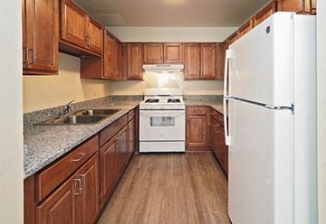 Buffalo apartment for rent - A kitchen with wooden cabinets and a white refrigerator.