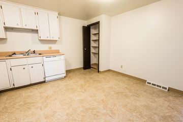 Amherst triplex for rent - A kitchen with white cabinets and a black door.