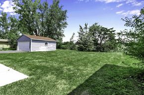 Amherst triplex for rent - A shed sits in a grassy field with trees in the background.