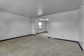 Amherst triplex for rent - A spacious room with a carpeted floor and a window.