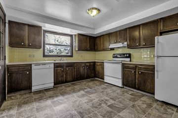 Amherst triplex for rent - A kitchen with brown cabinets and a white refrigerator.